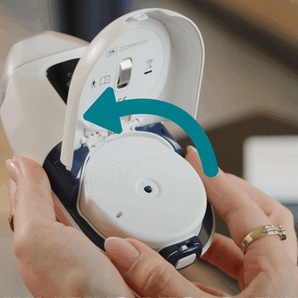יד מחזיקה משאף SyqeAir, מכסה המחסנית פתוח. היד מראה כיצד מסובבים שמאלה את המחסנית לשם הוצאתה מהתושבת שלה.